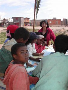Nasrin Siege with a group of children at a reading table in Africa